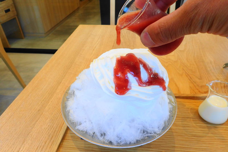 笠間 ふる川製菓 のかき氷（生苺ミルク）にソース投入の図