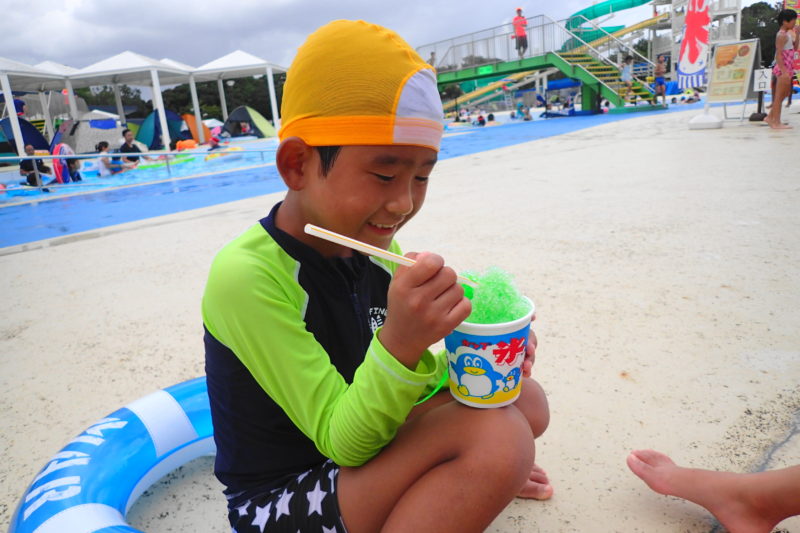 プールサイドでかき氷を食べる子